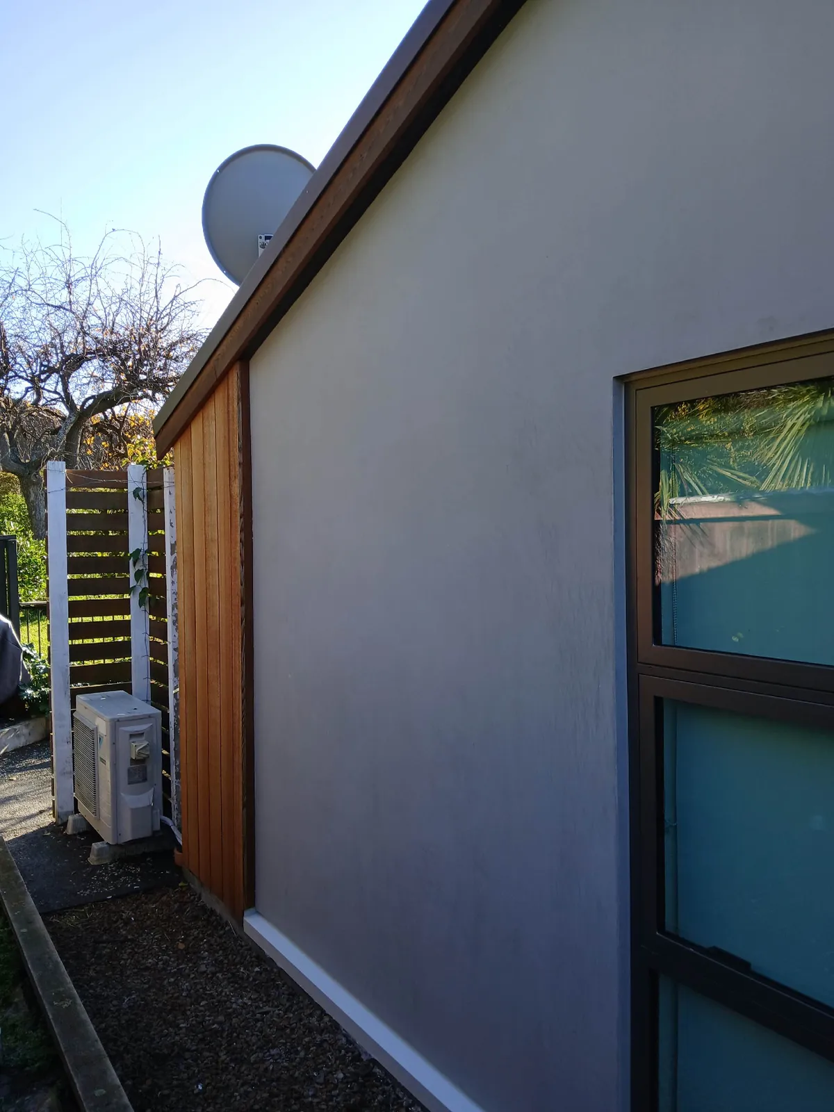 Render and cedar cladding detail against a blue sky